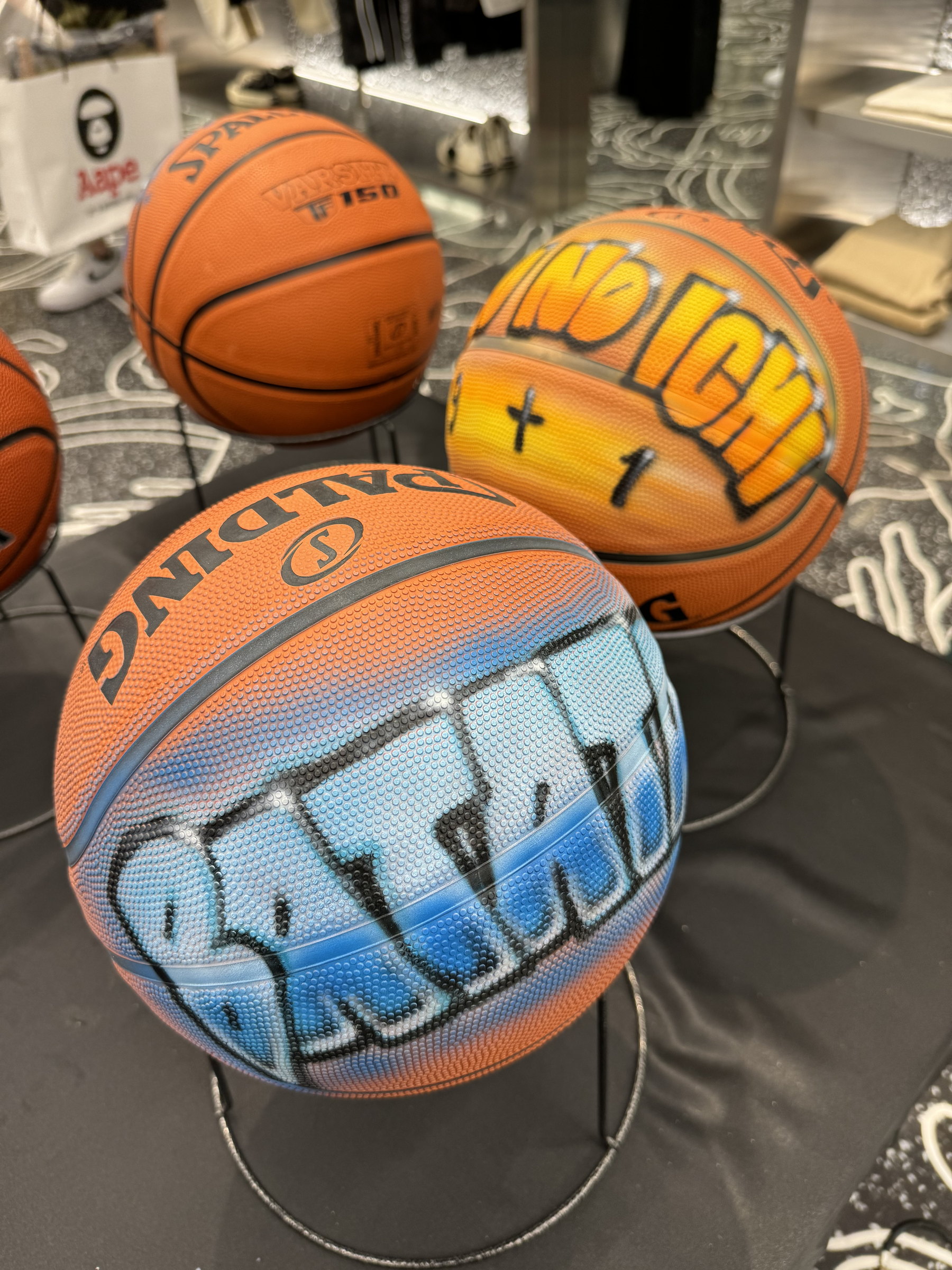 Three airbrushed basketballs on stands