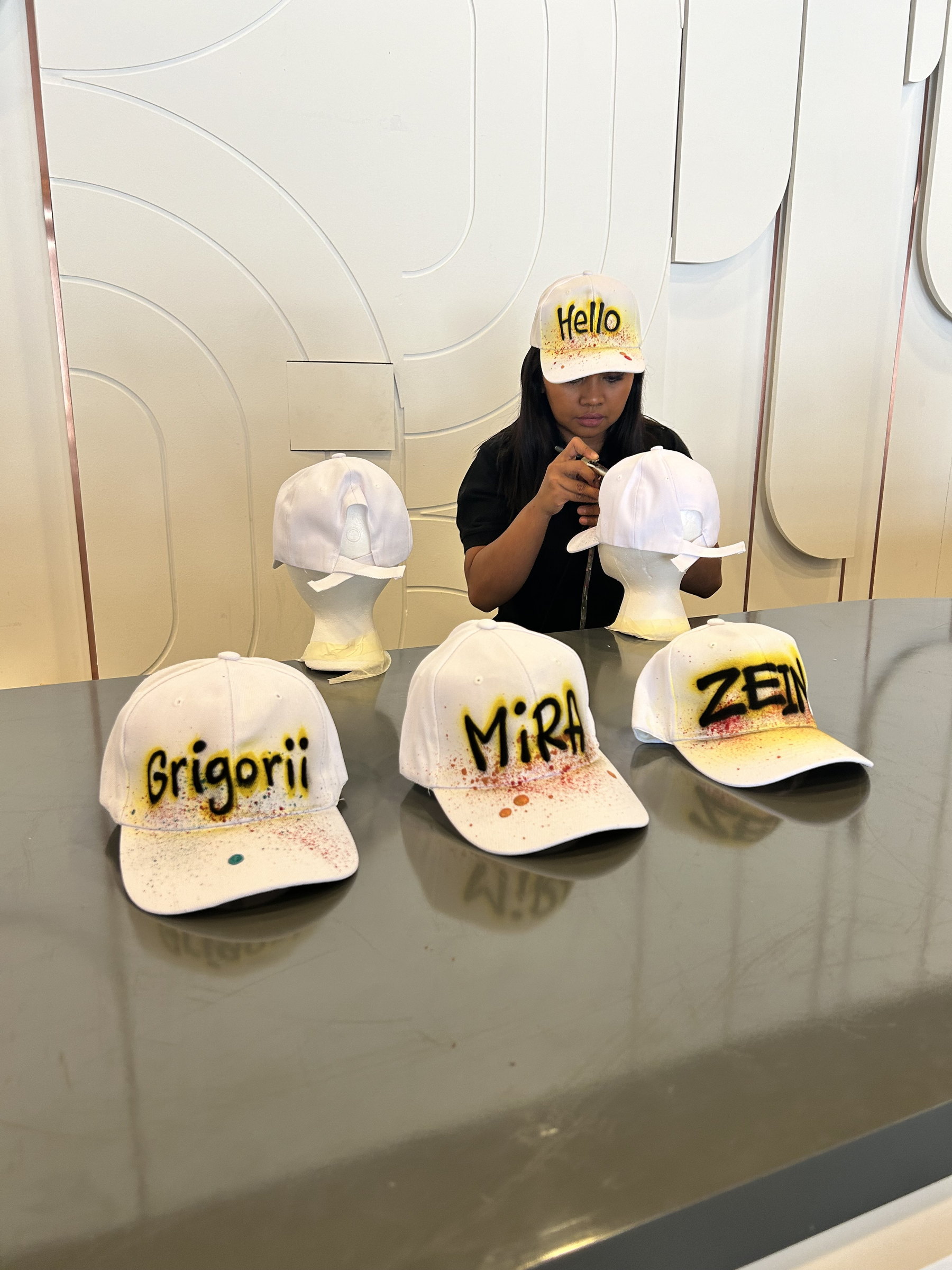 Airbrushed caps lined up on a counter