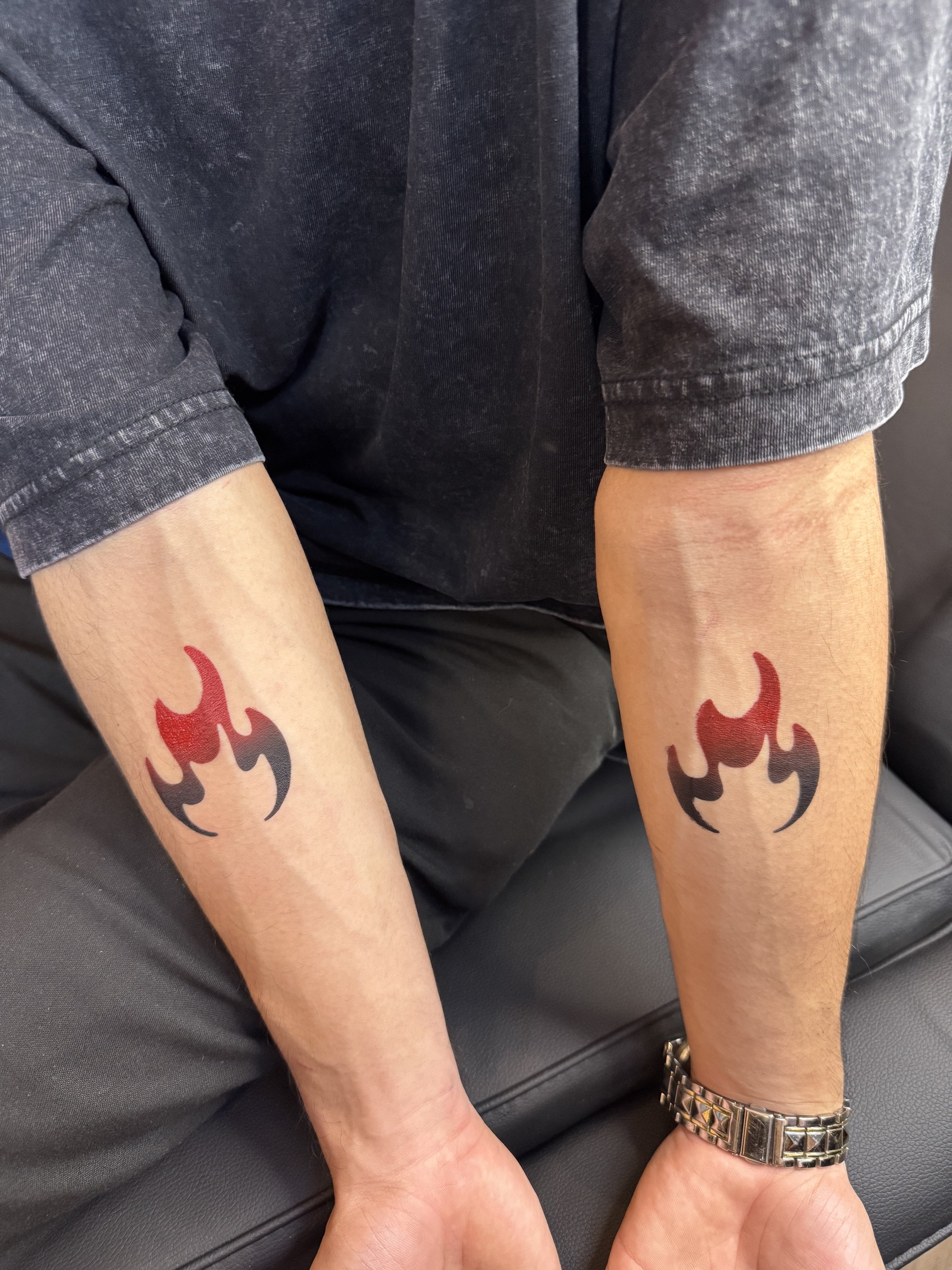 Airbrushed flame tattoos on two forearms
