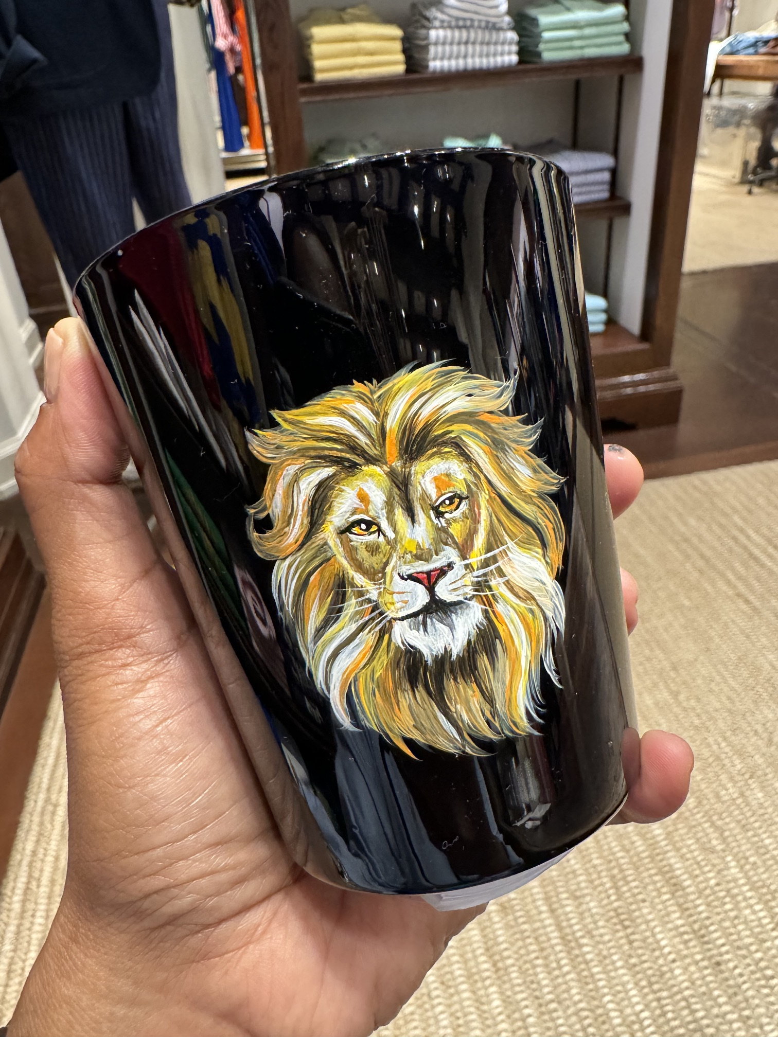 Gold lion painted on a black candle jar