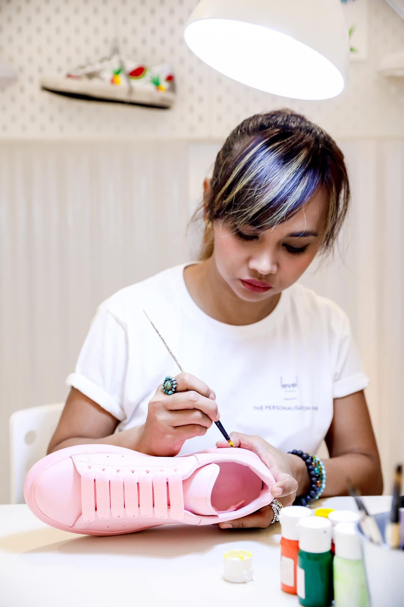Ella painting at the counter with brushes and paint pots