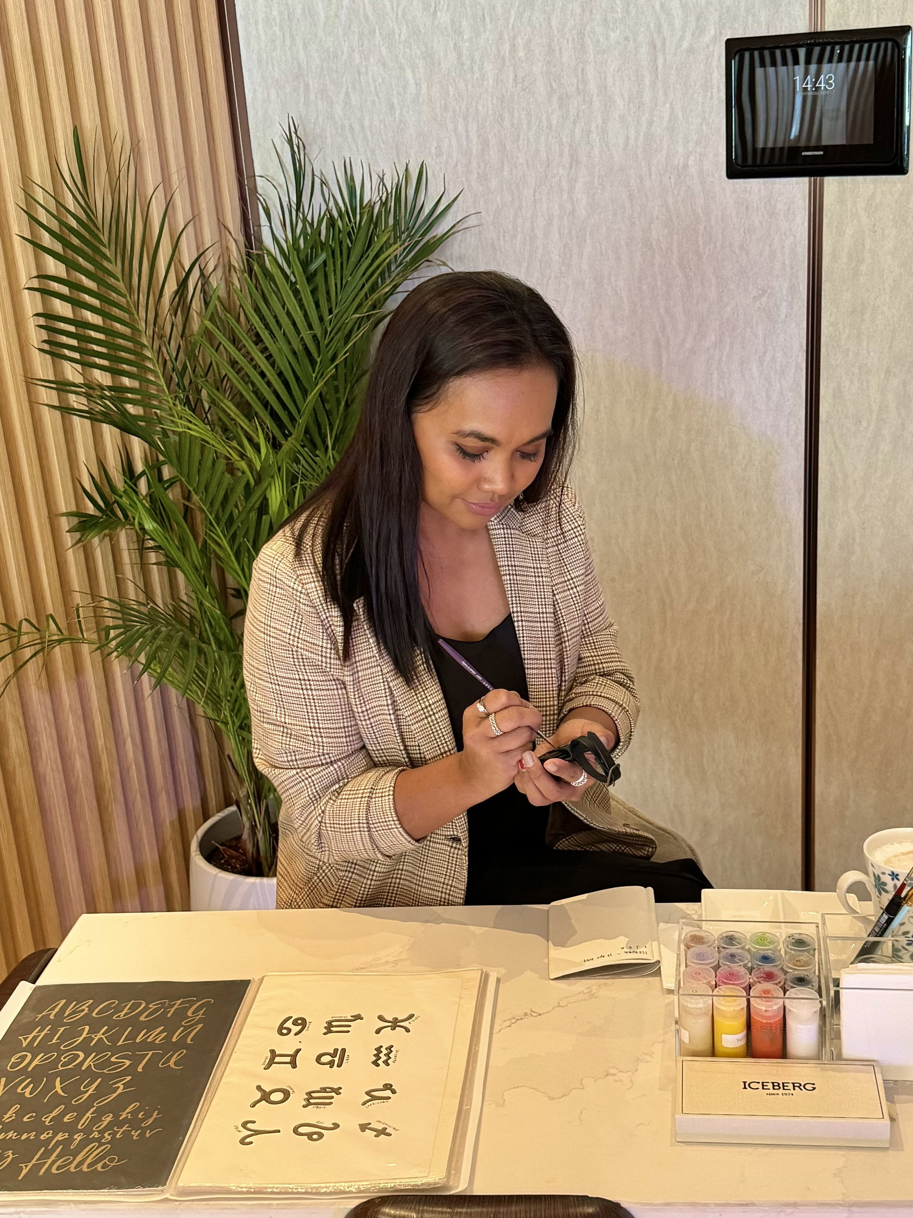 Ella painting luggage tags at a table