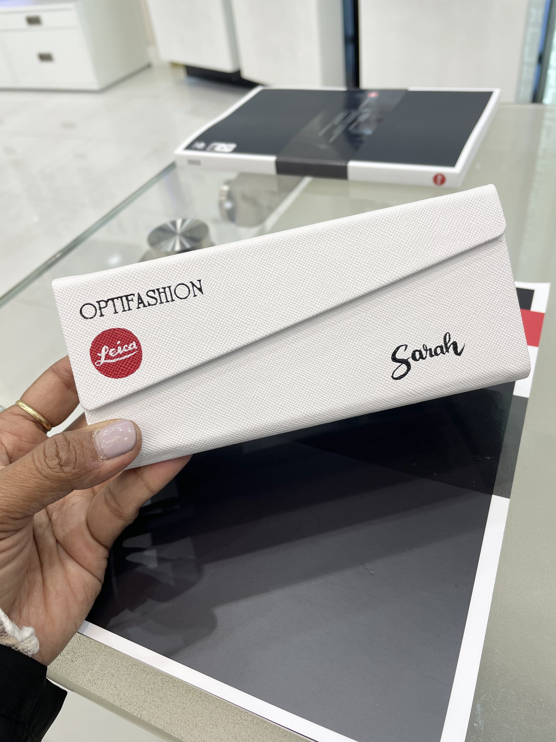 'Sarah' lettered on a white sunglass case