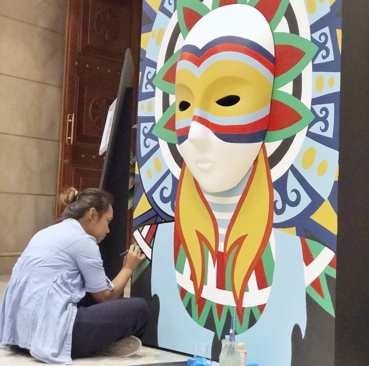Ella painting a mask live at the festival